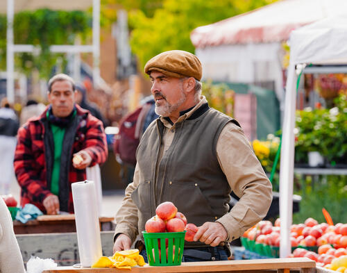 marchand donne des pommes dans un marché