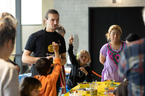 un adulte aide un enfant à cuisiner