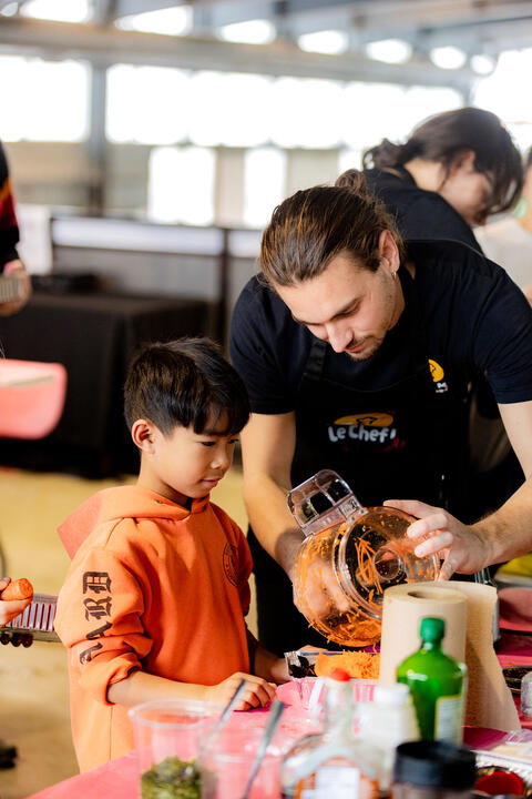 un adulte aide un enfant à cuisiner